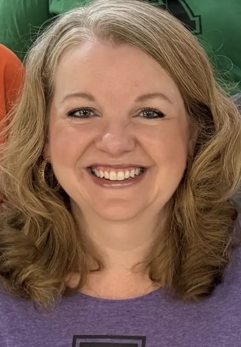 Image is of the AHA counselor. She is blonde and smiling, and is wearing a purple shirt with a large A and eagles written below it.